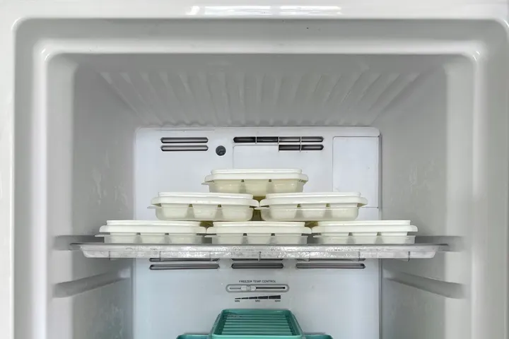 Открытая морозильная камера с контейнерами и лотками для льда